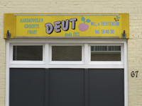 901016 Afbeelding van de buitenreclame van aardappelen-, groente- en fruithandel 'DEUT' (W.L. van Deutekom, ...